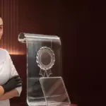 Врач-косметолог у стеклянной скульптуры диплома с печатью
